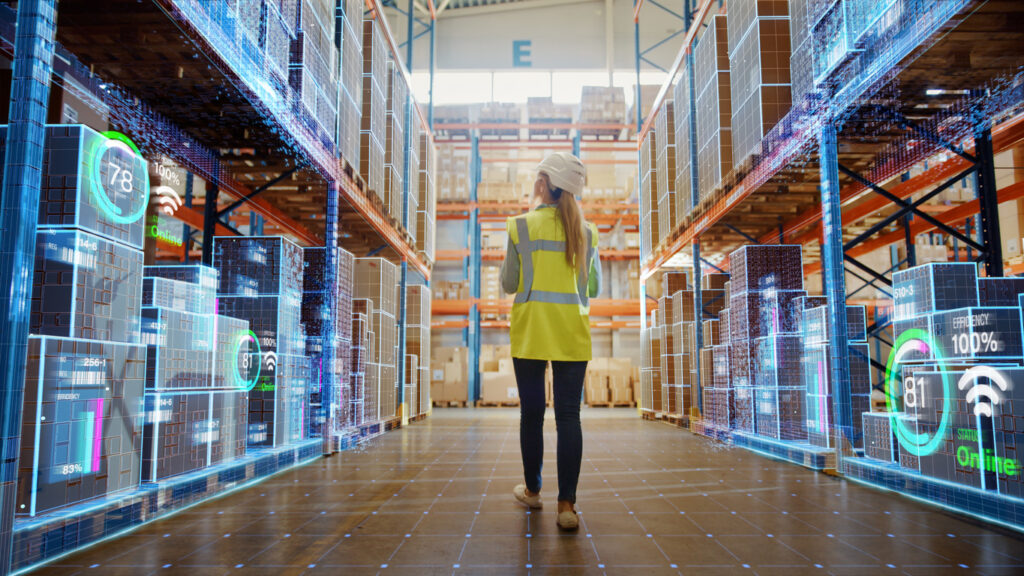 woman walking through warehouse with technology graphics