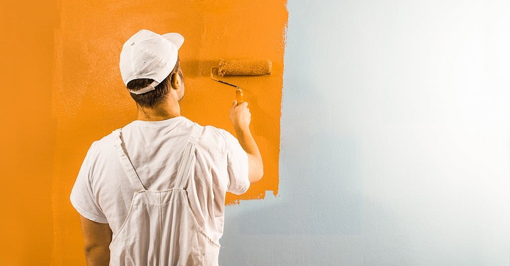 man painting wall with performance paint