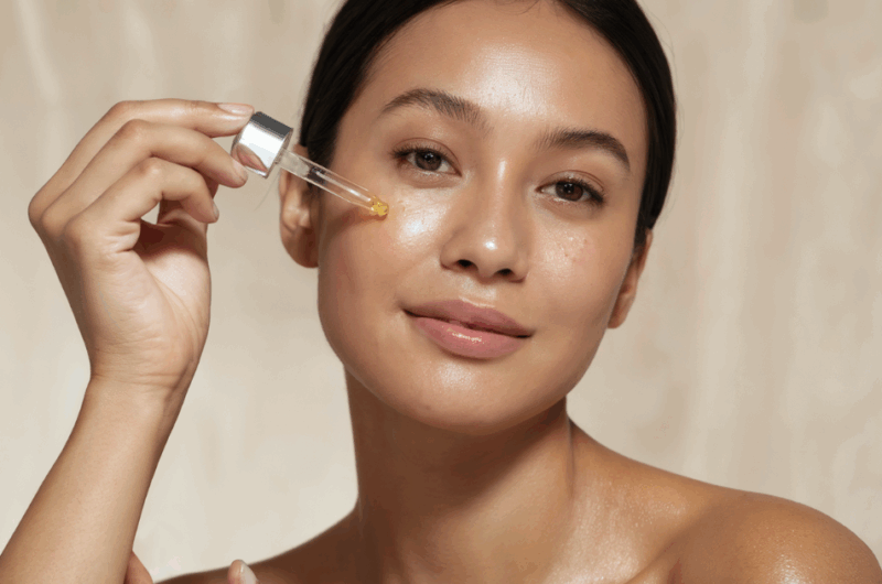 woman dropping a skincare serum on her face